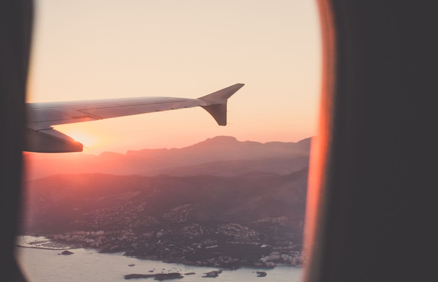 View from the airplane window of the sunset above the clouds — traveling to Florida.