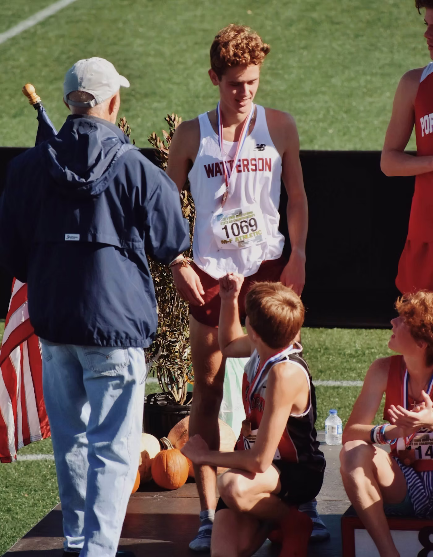 Young athlete celebrating with a medal at an awards ceremony.