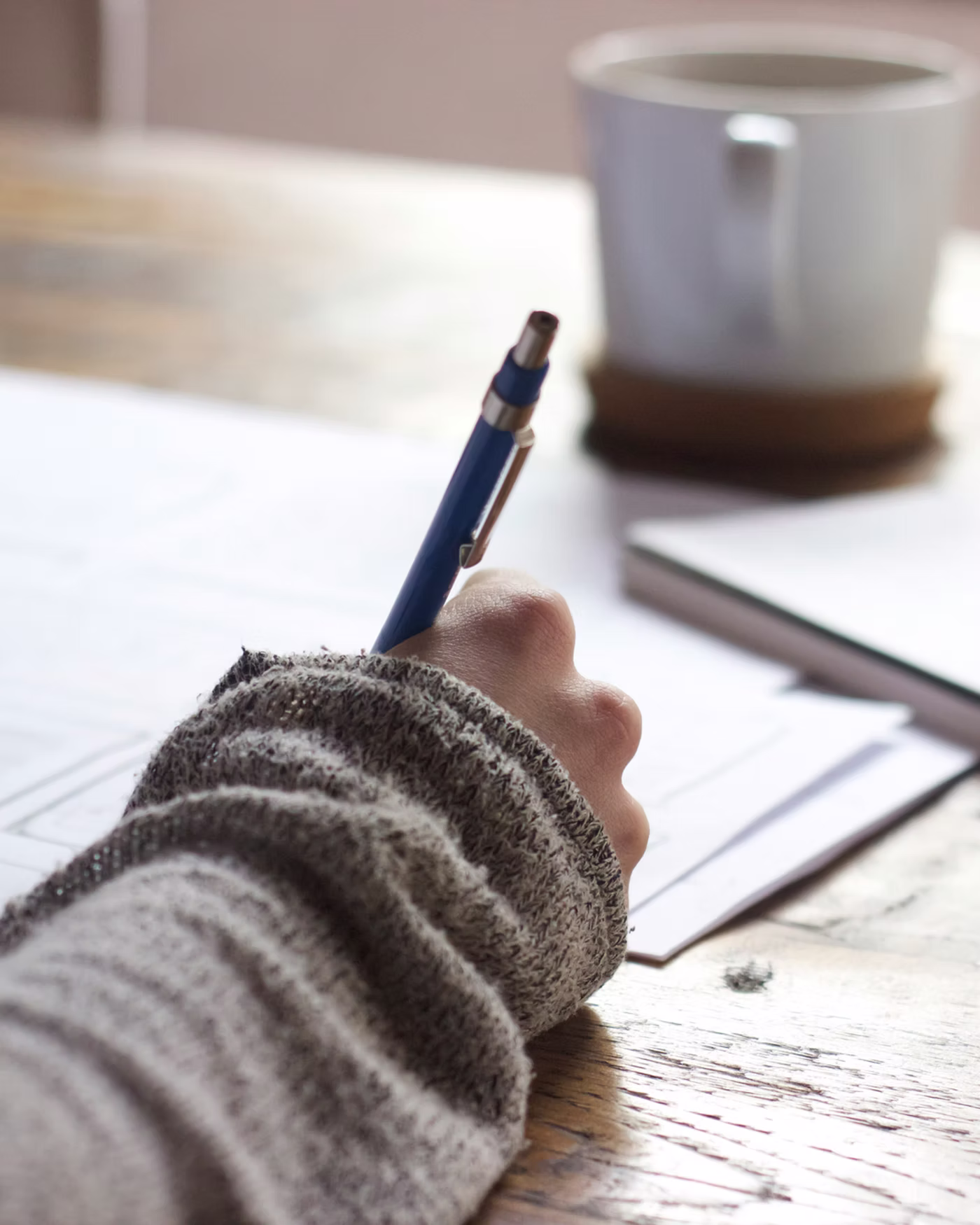 Writing notes at a desk with pen and mug – college entrance exams.