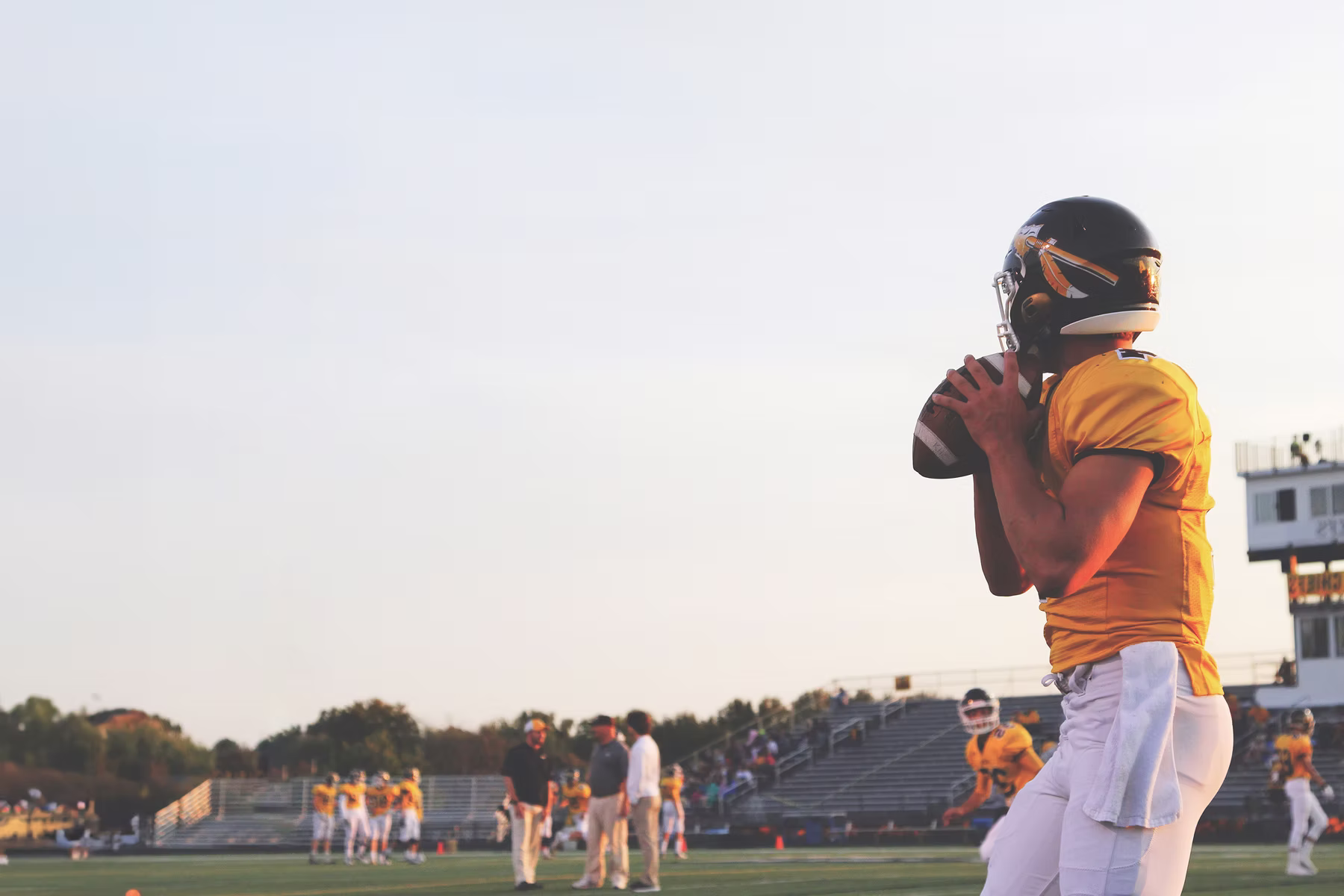 American football player standing in the sunset on the field.