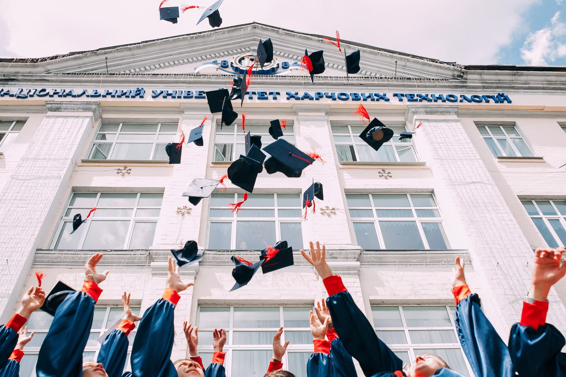 Students throwing their graduation caps into the air.