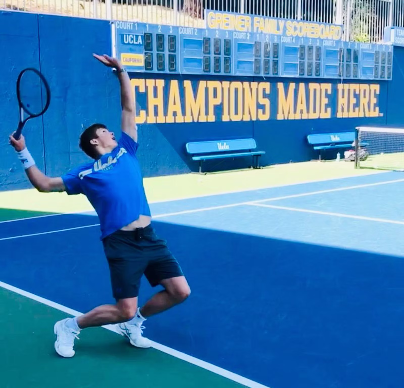 Tennisspieler beim Aufschlag auf einem blauen Tennisplatz mit präziser Körperhaltung.