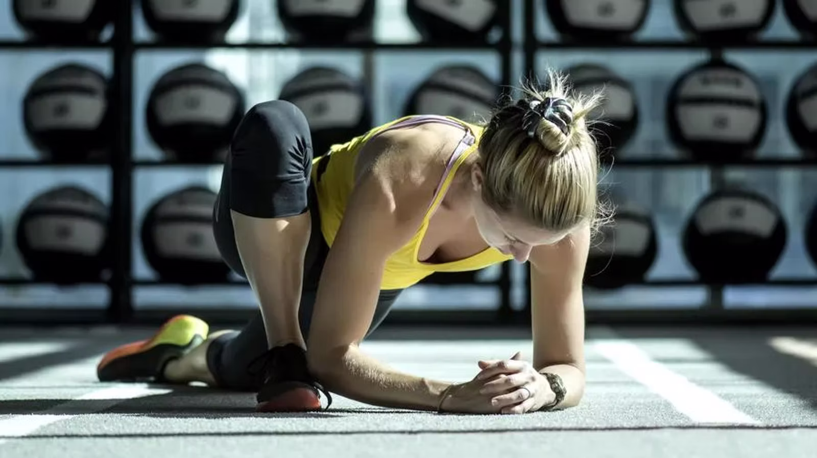 Athletin beim Dehnen im Fitnessraum — Mobility und Athletik.