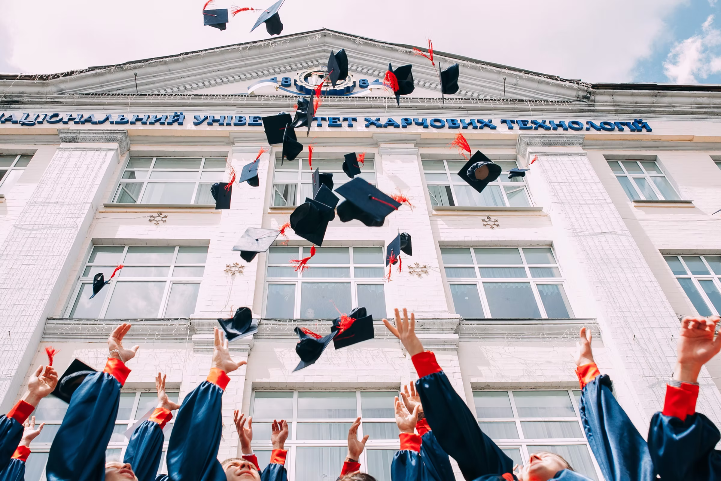 College graduates celebrating with caps in the air — symbolising Yuliia’s academic and athletic milestones.